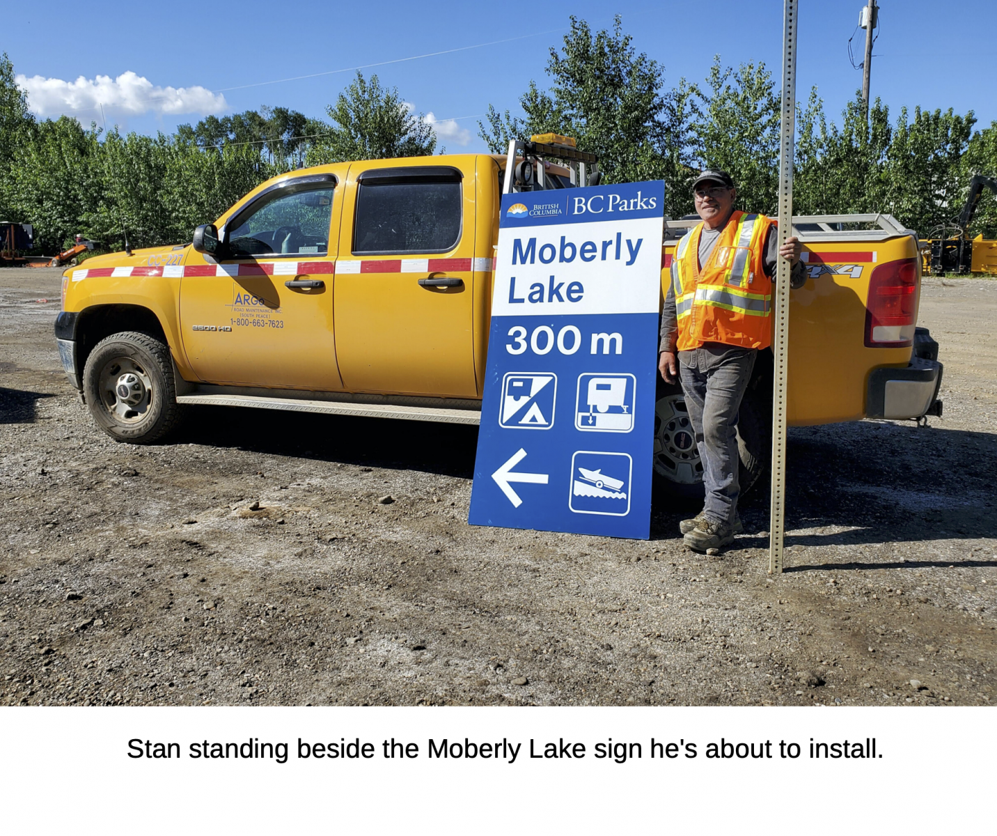 Stan standing beside the Moberly Lake sign he's about to install.
