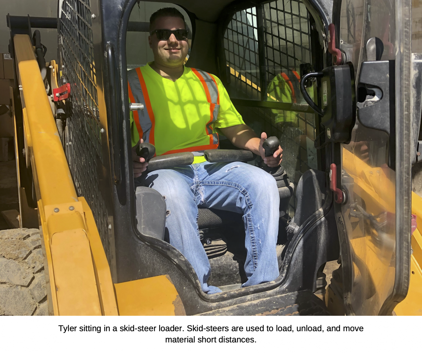Tyler sitting in a skid-steer loader. Skid-steers are used to load, unload, and move material short distances.